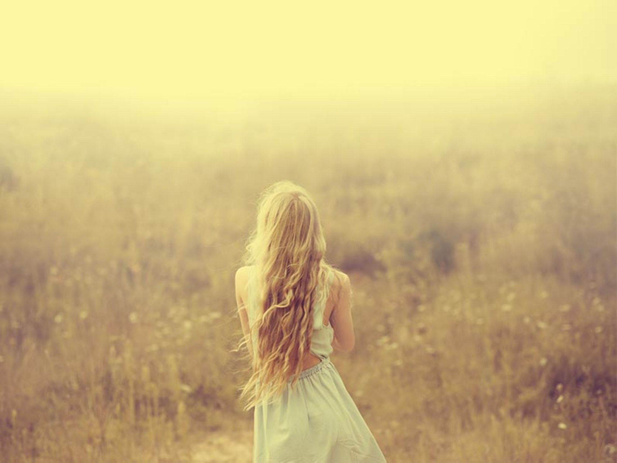 Frau mit langem Haar in einer sommerlichen Landschaft